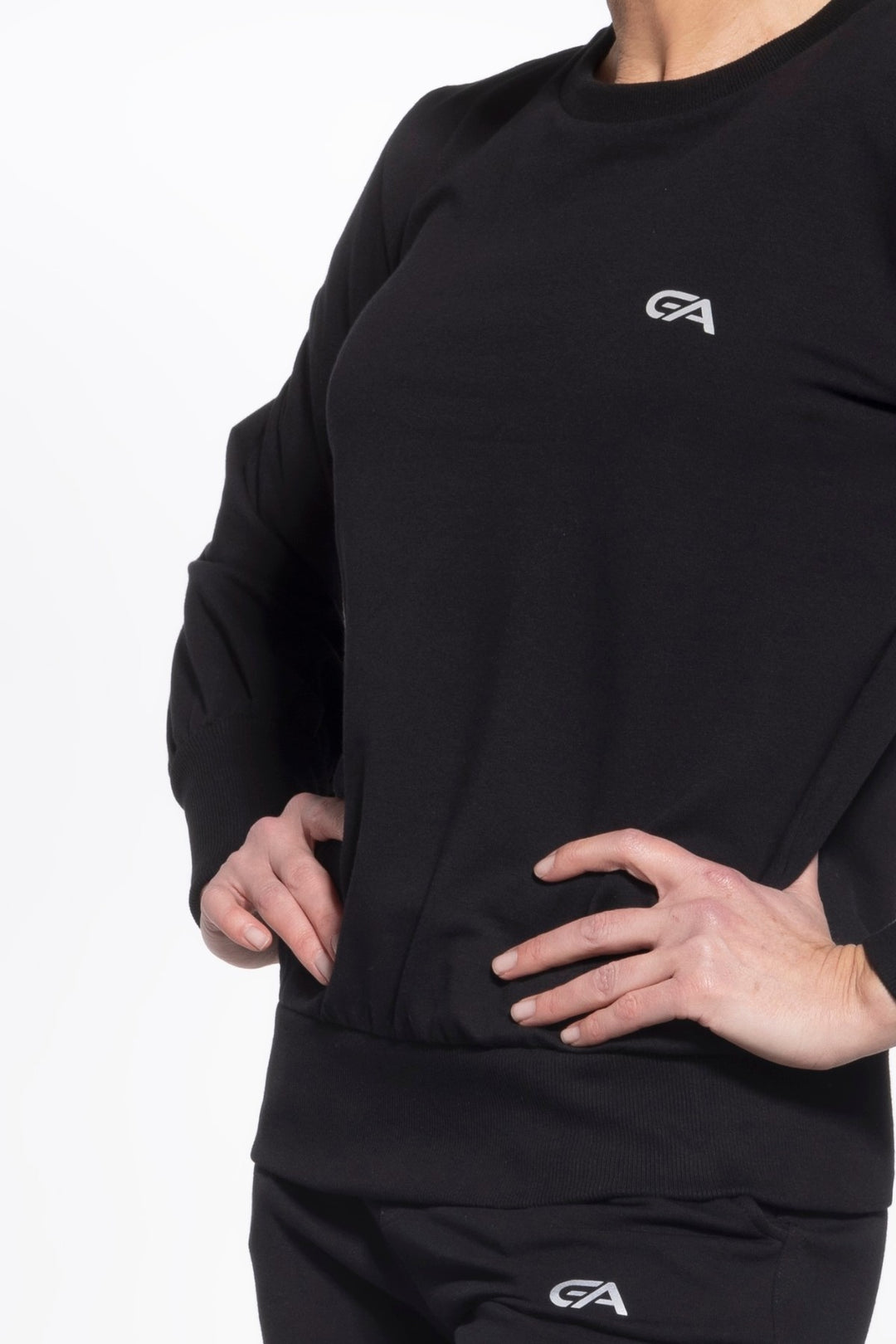 Person wearing a black long-sleeve shirt with a logo on a white background