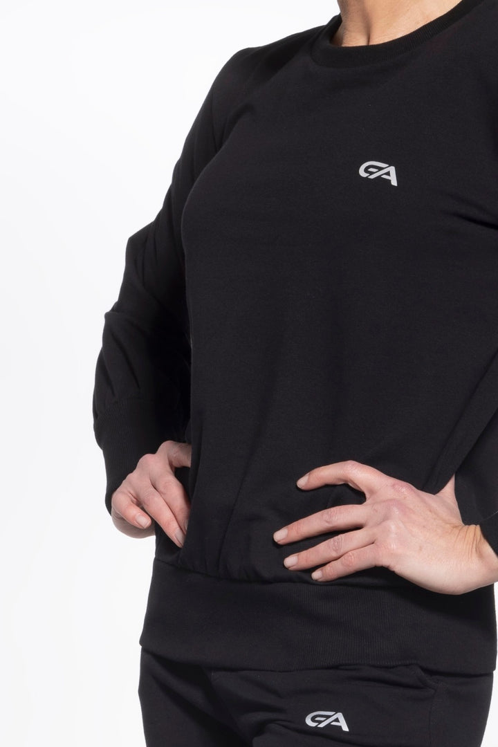 Person wearing a black long-sleeve shirt with a logo on a white background