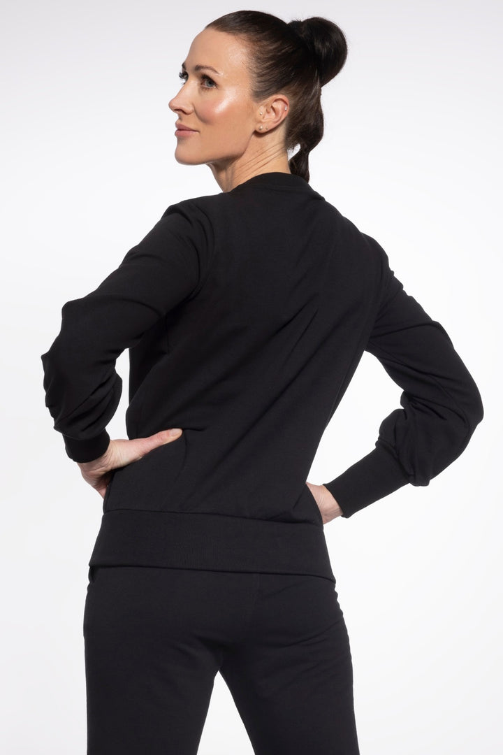 Woman wearing a black outfit against a white background