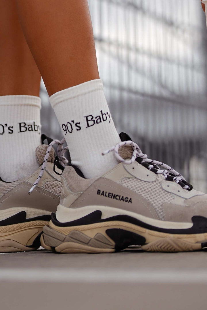 Close-up of ecru cotton socks with "90's Baby" slogan – bold lettering on soft breathable fabric

