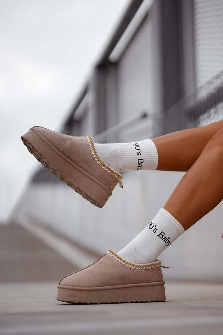 Ecru "90's Baby" cotton socks styled with UGG shoes – side view showing slogan and fit

