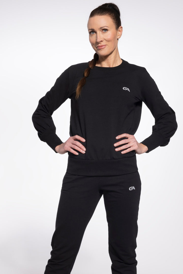 Woman wearing a black outfit with a logo on a white background