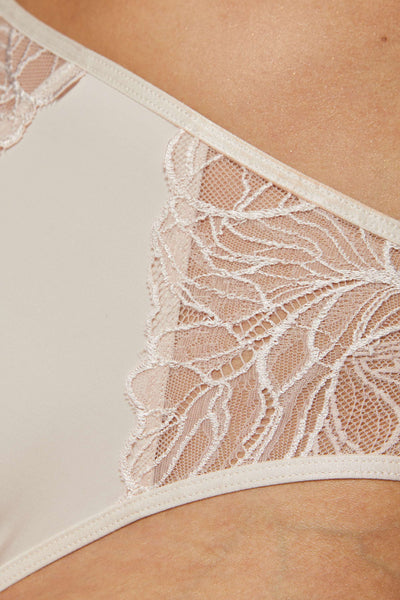 Close-up of the Femme beige panty, showing ivory lace panels meeting the smooth front.