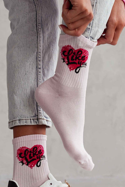 Close-up of powder pink cotton socks with "I Like You" slogan – bold lettering on soft fabric
