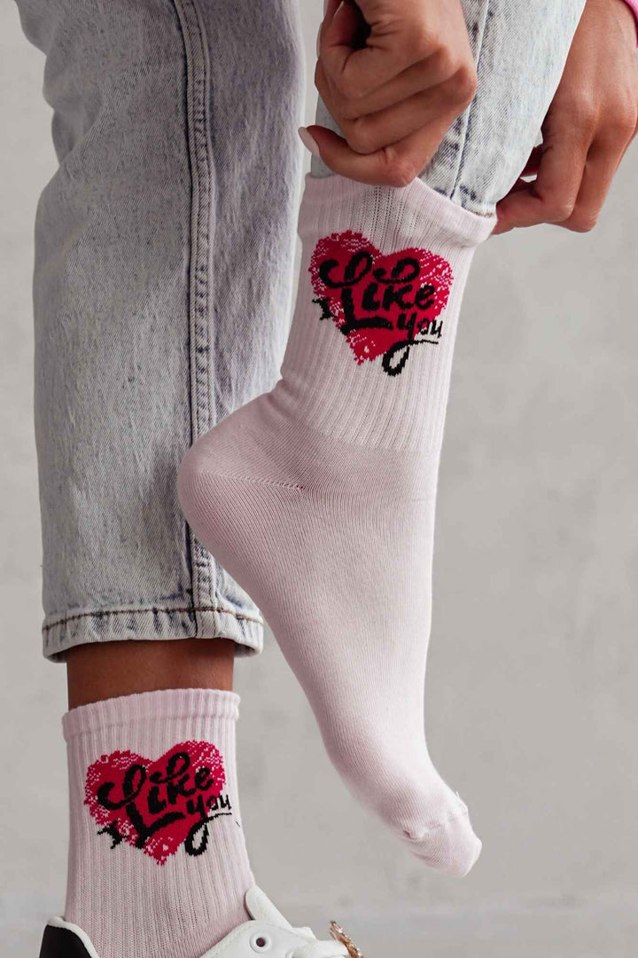 Close-up of powder pink cotton socks with "I Like You" slogan – bold lettering on soft fabric
