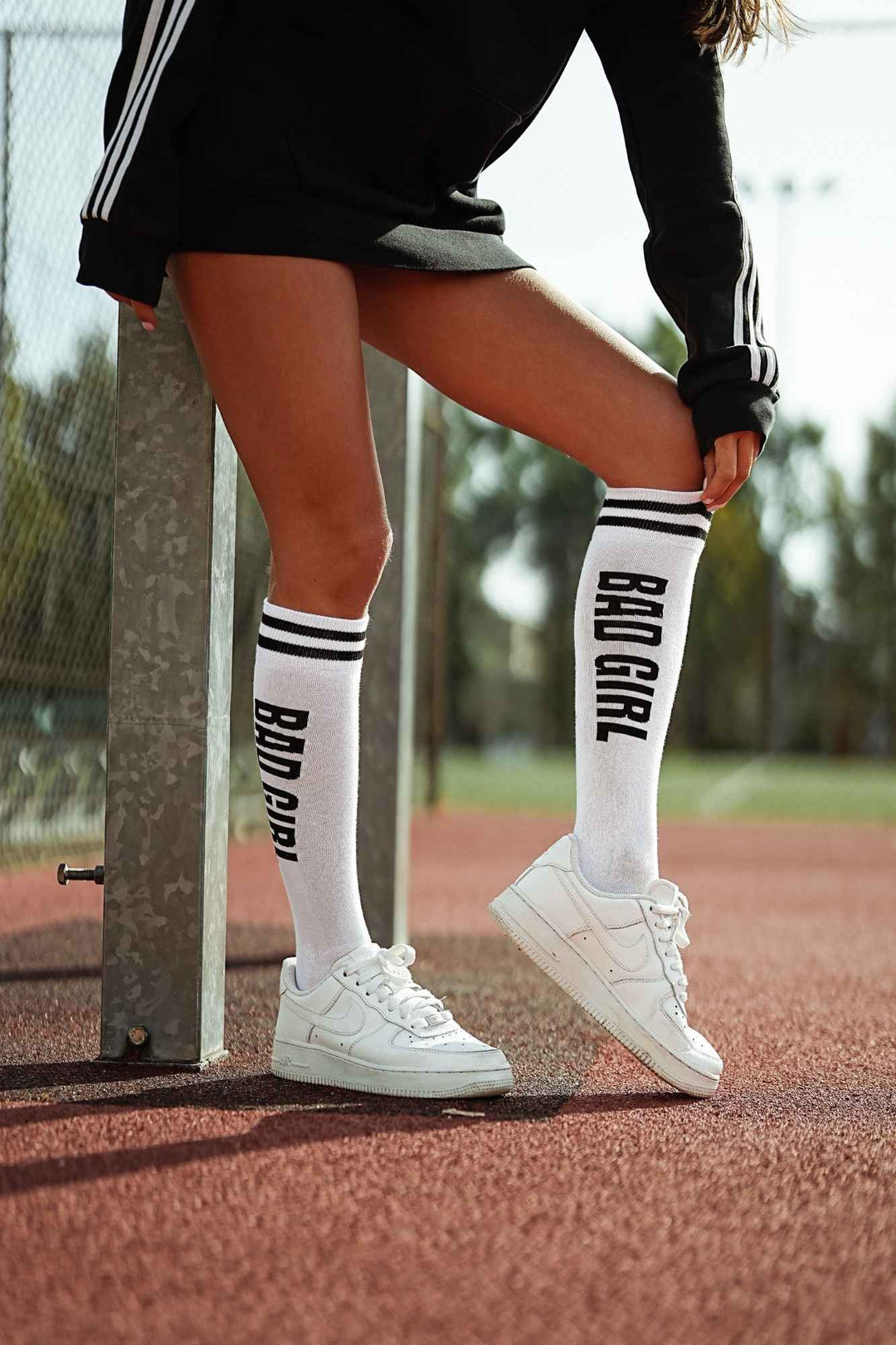 White and black "Bad Girl" cotton knee socks – side view showing slogan print and full length
