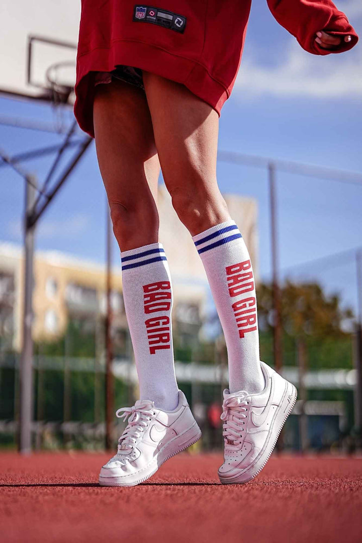 White and red "Bad Girl" cotton knee socks – front view showing slogan print and full length
