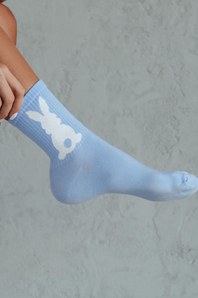 Close-up of blue cotton socks with bunny tail – fluffy tail detail on soft breathable fabric
