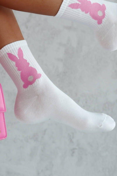 Close-up of pink cotton socks with bunny tail – fluffy tail detail on soft breathable fabric
