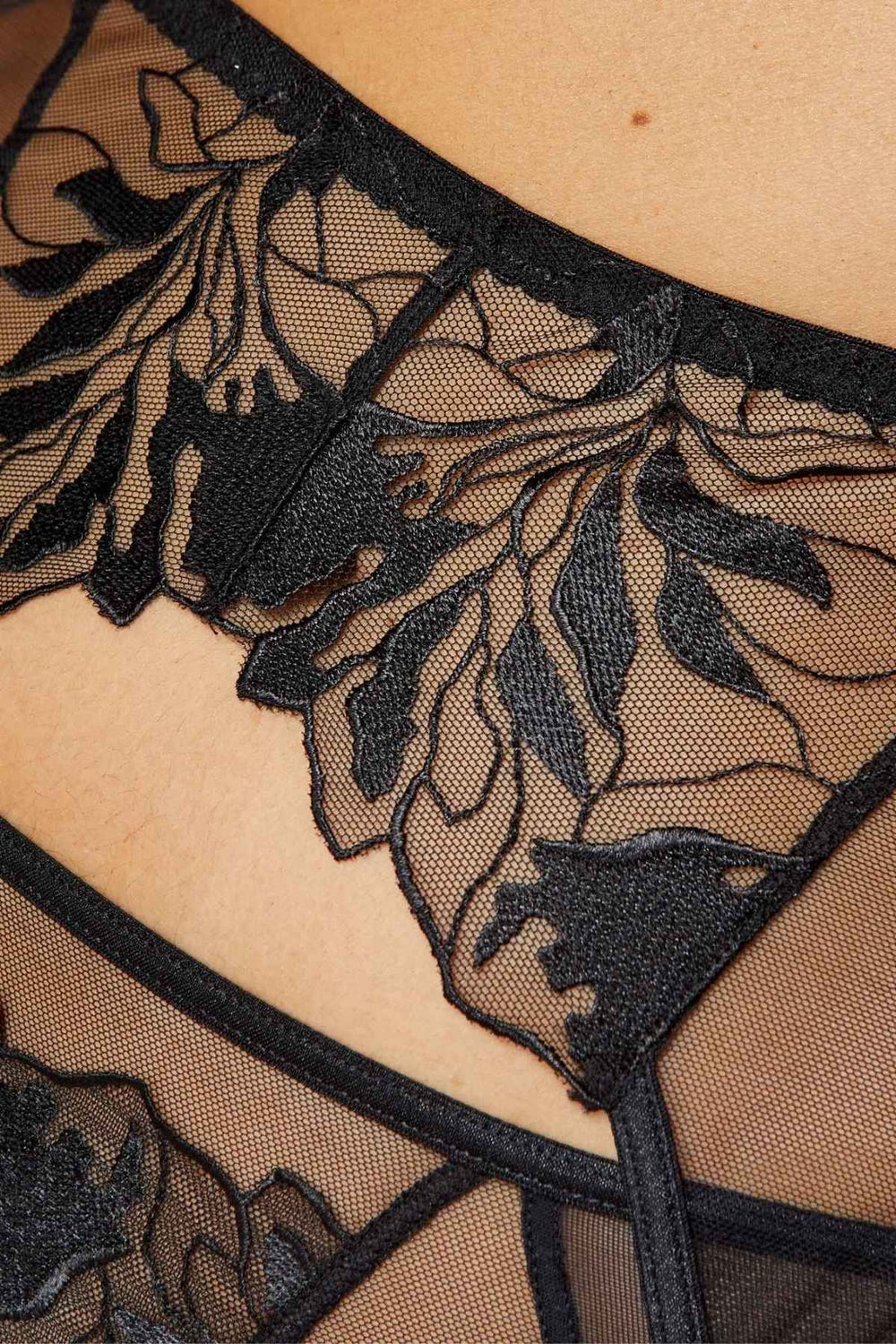 Black lace lingerie with floral patterns on a beige background