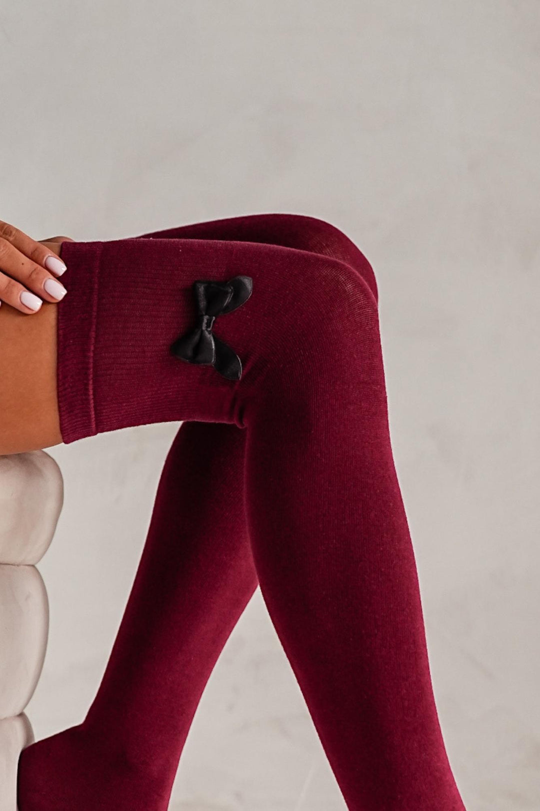 Close-up of claret cotton over-knee socks – bow detail on soft breathable fabric
