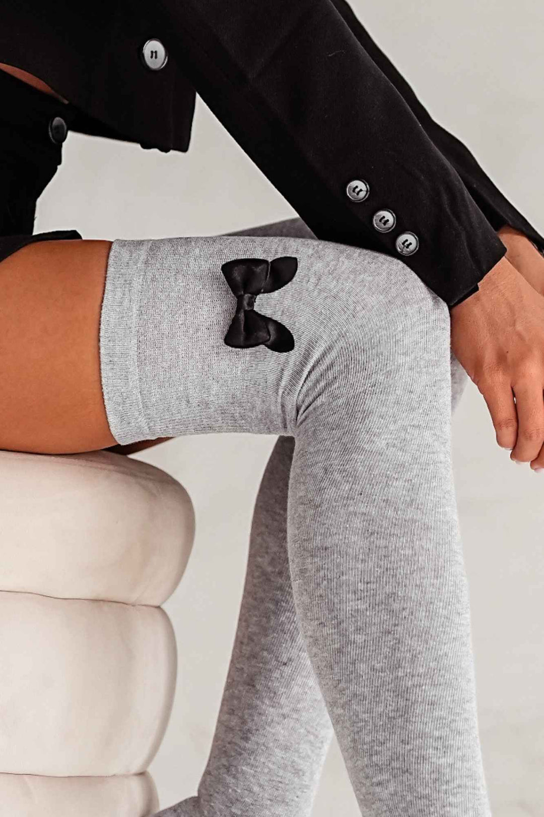Close-up of light melange cotton over-knee socks – bow detail on soft breathable fabric
