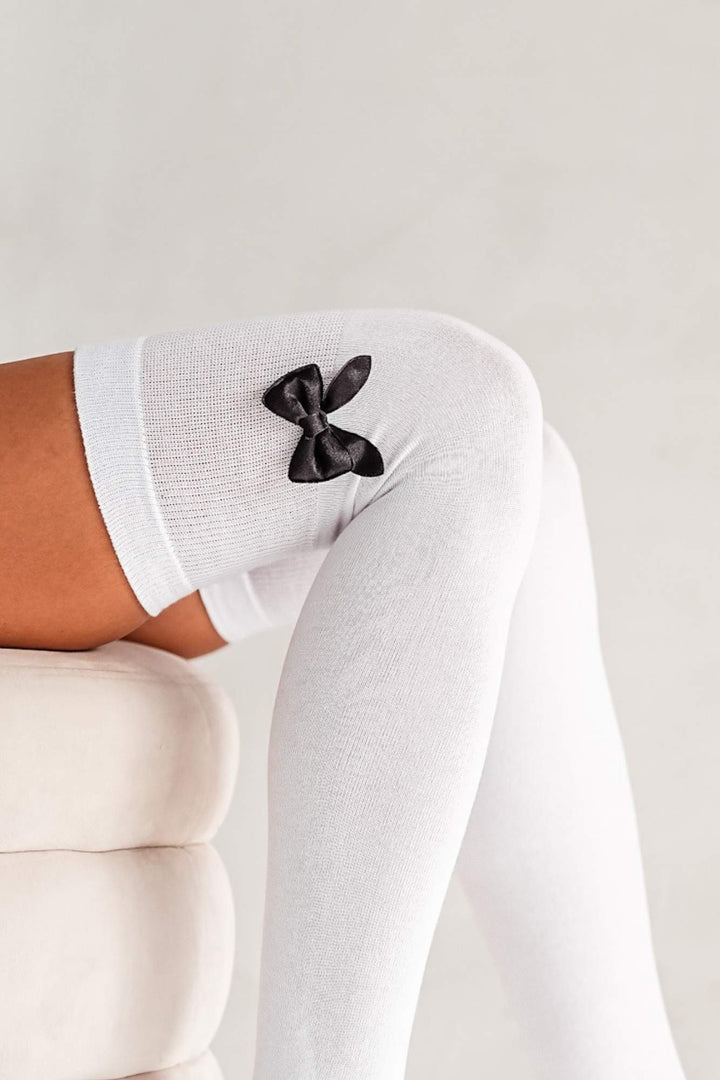 Close-up of white cotton over-knee socks – bow detail on soft breathable fabric
