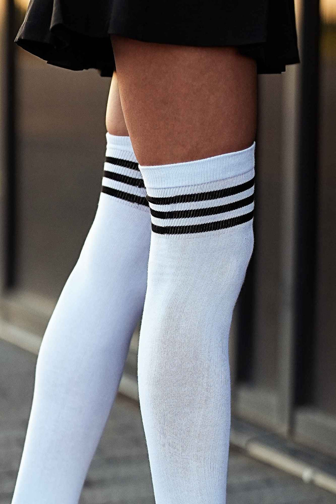 Close-up of white and black over-knee socks – striped welt detail on soft cotton fabric
