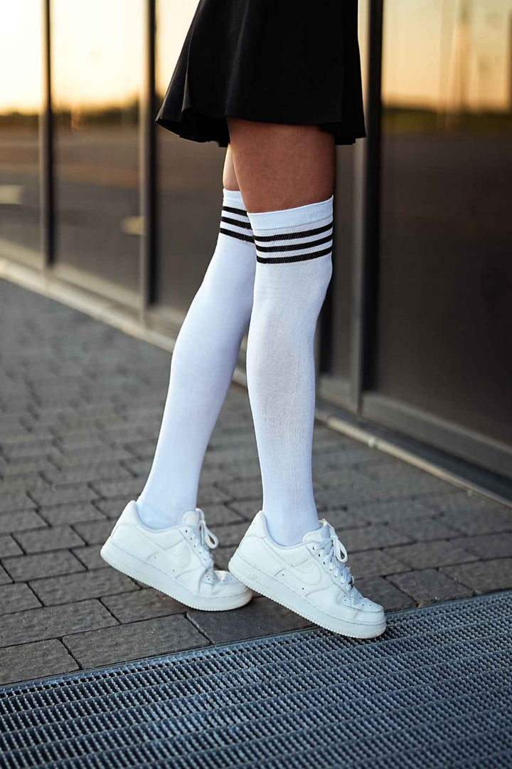 White and black cotton over-knee socks with striped welt – side view showing stripe detail and full length

