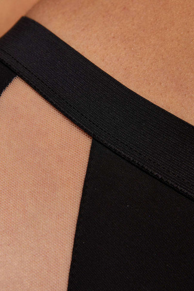 Close-up of the Merida panty's wide black waistband above a sheer nude mesh panel.