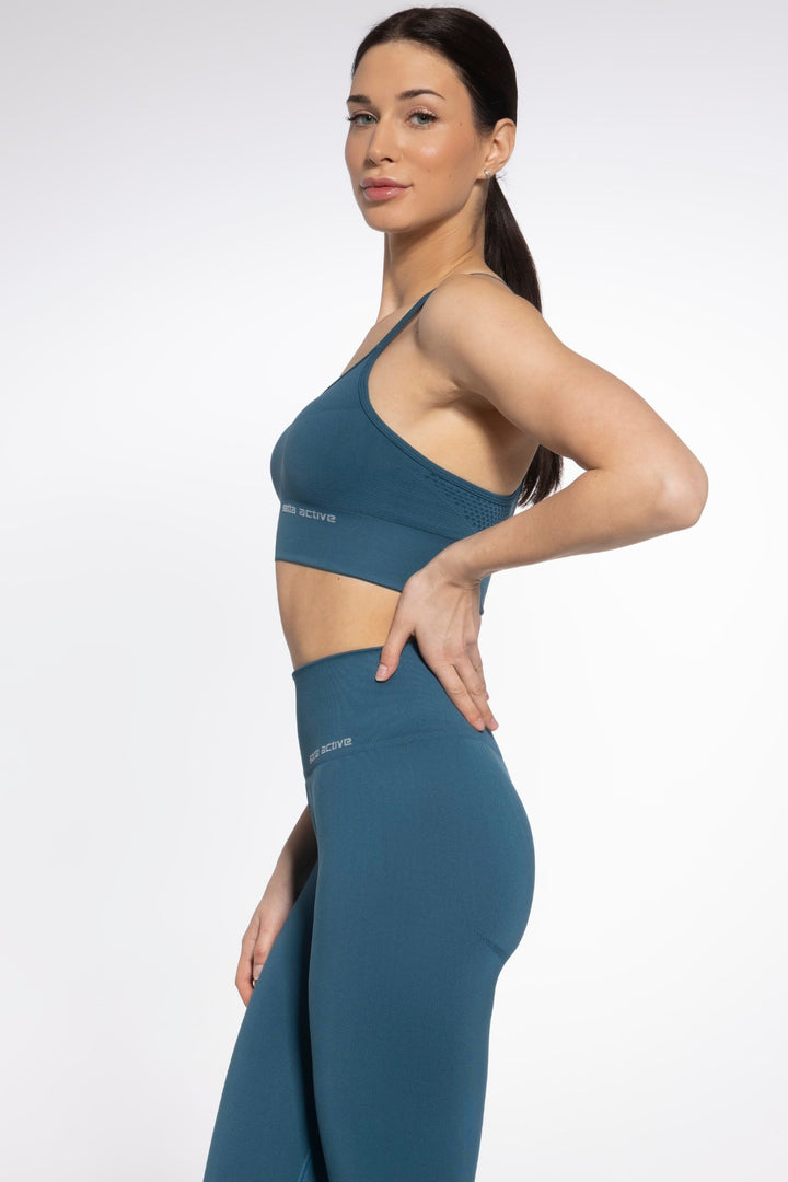 Side profile of Gatta Active seamless bra in noble green with wide elastic band
