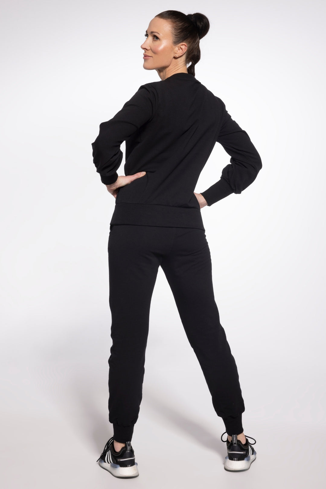 Woman wearing a black tracksuit on a white background