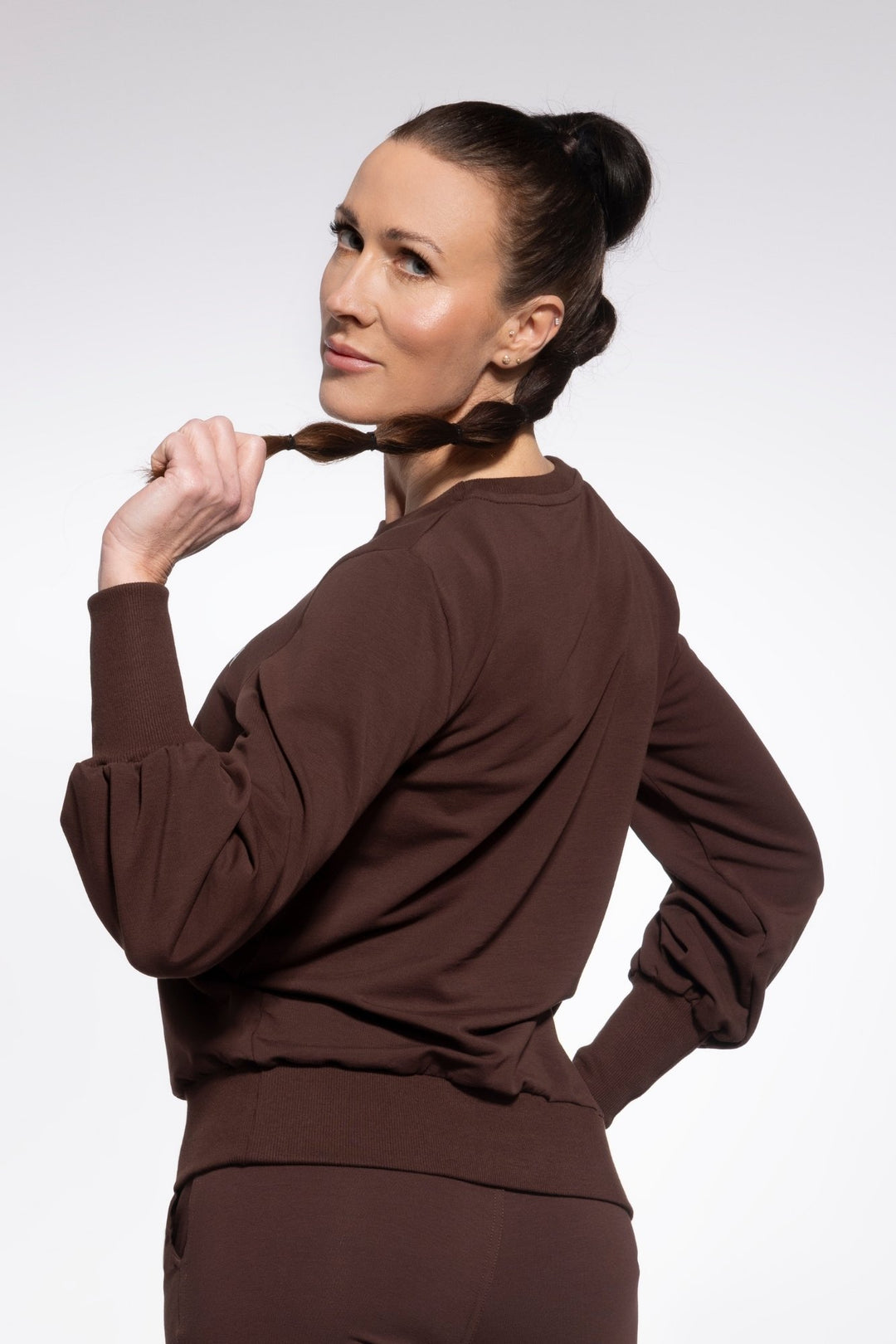 Woman wearing a brown outfit against a white background