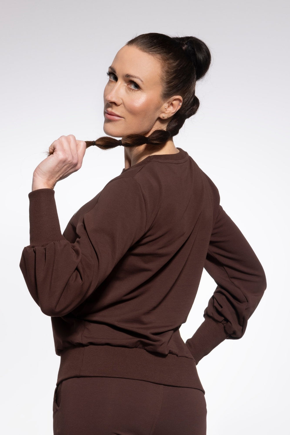 Woman wearing a brown outfit against a white background