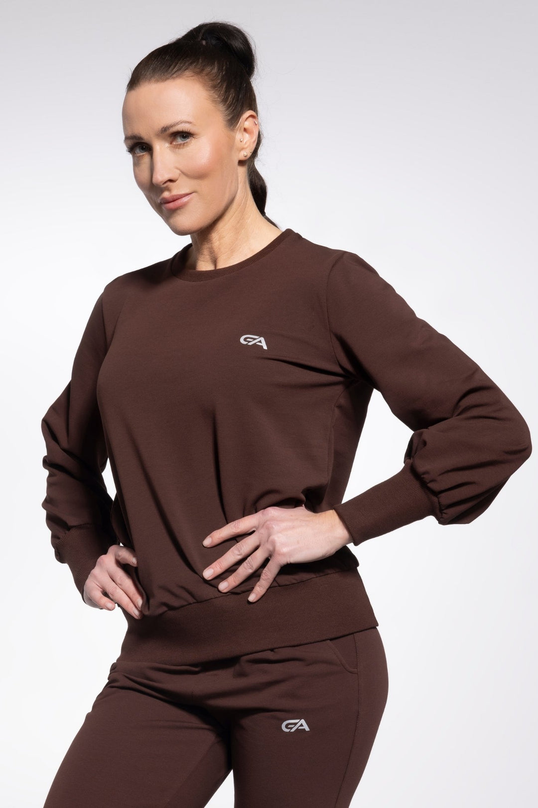 Woman wearing a brown outfit with a logo on a white background