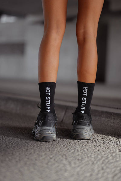 Black cotton socks with "Hot Stuff" text print – back view showing slogan and ankle fit
