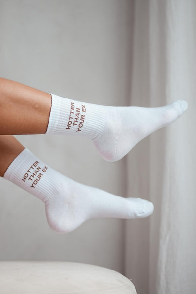 White cotton socks with "Hotter Than Your Ex" text print – side view showing slogan and ankle fit
