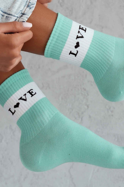 Close-up of mint cotton socks with "Love" slogan – bold lettering on soft breathable fabric
