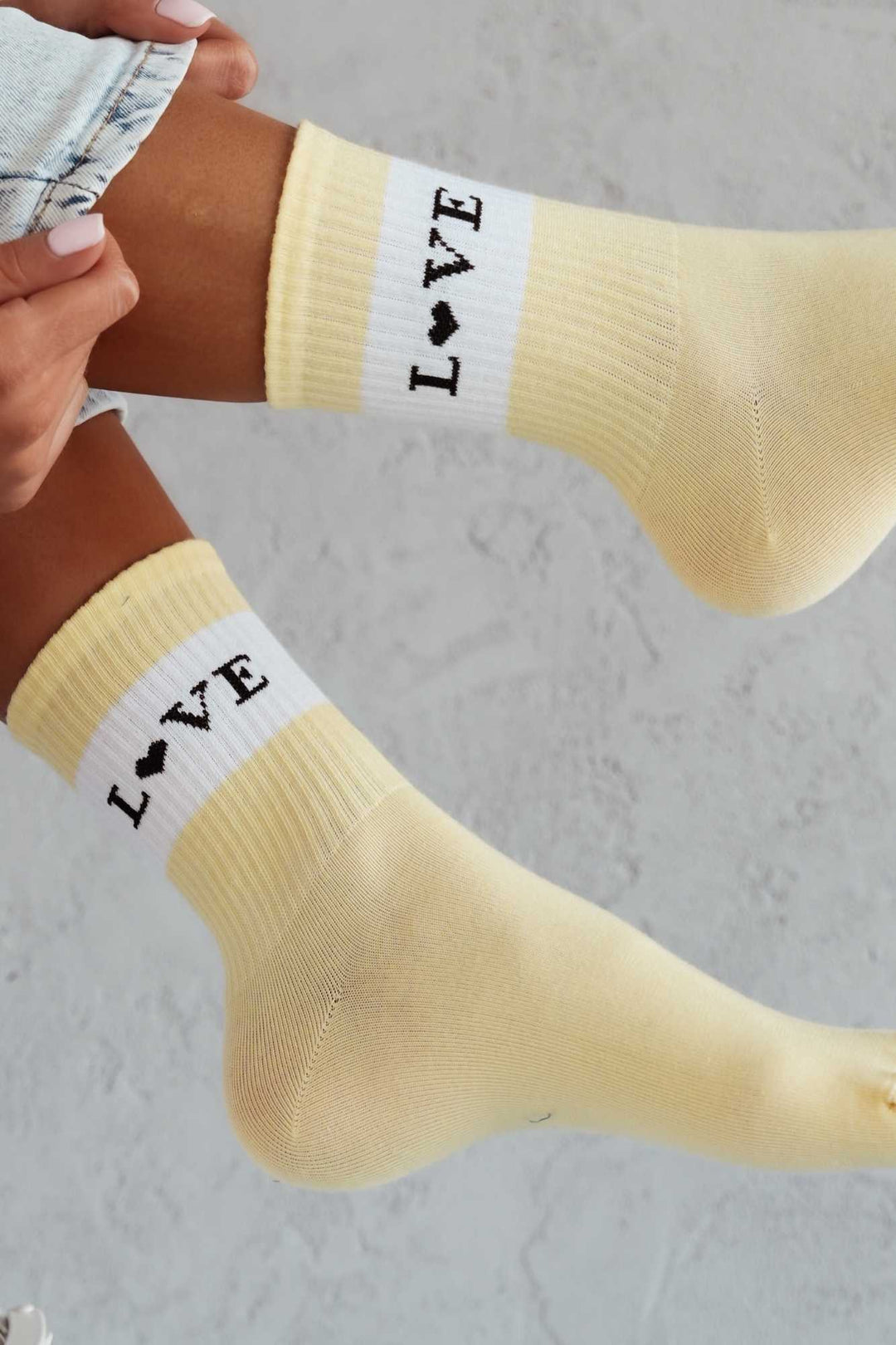 Close-up of yellow cotton socks with "Love" slogan – bold lettering on soft breathable fabric
