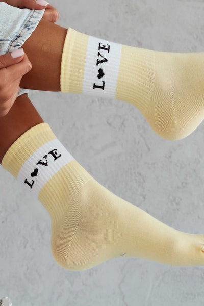 Close-up of yellow cotton socks with "Love" slogan – bold lettering on soft breathable fabric
