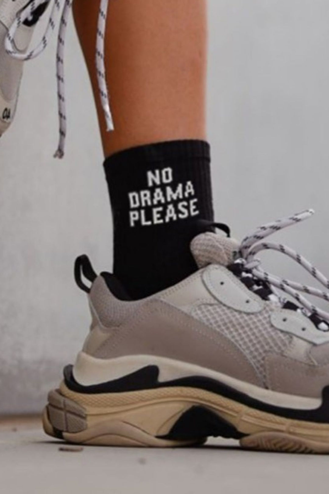 Close-up of black cotton socks with "No Drama Please" slogan – bold lettering on soft fabric
