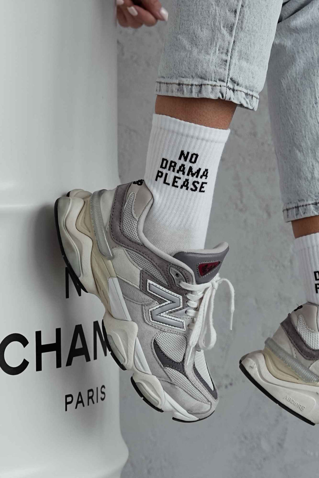 Close-up of white cotton socks with "No Drama Please" slogan – bold lettering on soft fabric
