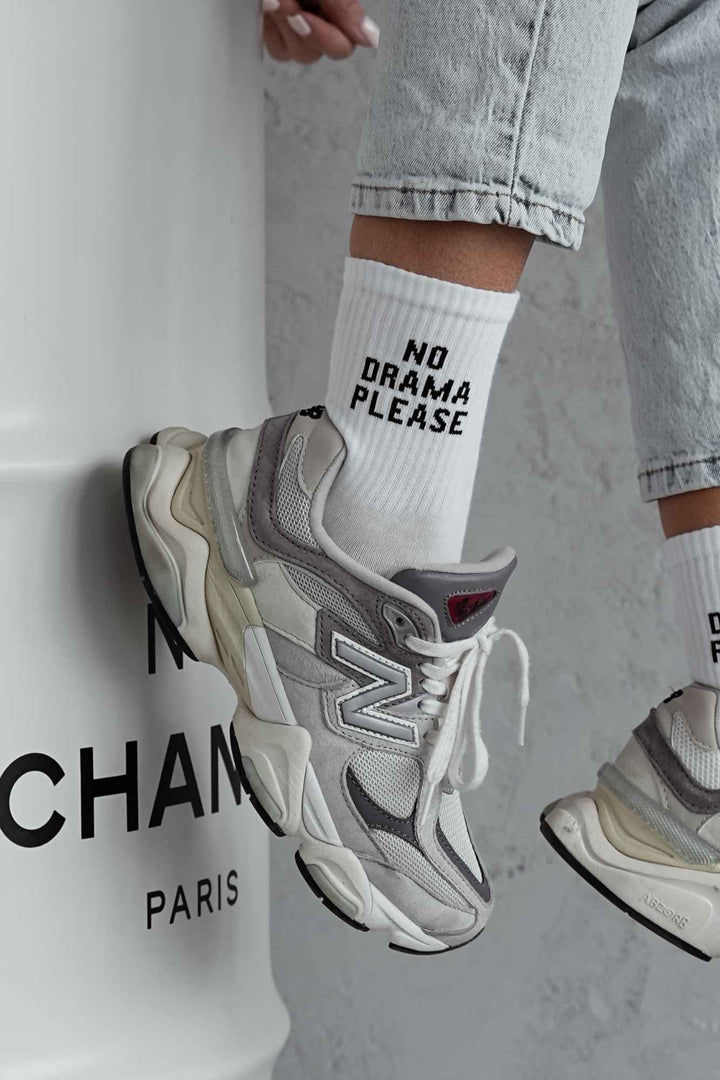 Close-up of white cotton socks with "No Drama Please" slogan – bold lettering on soft fabric
