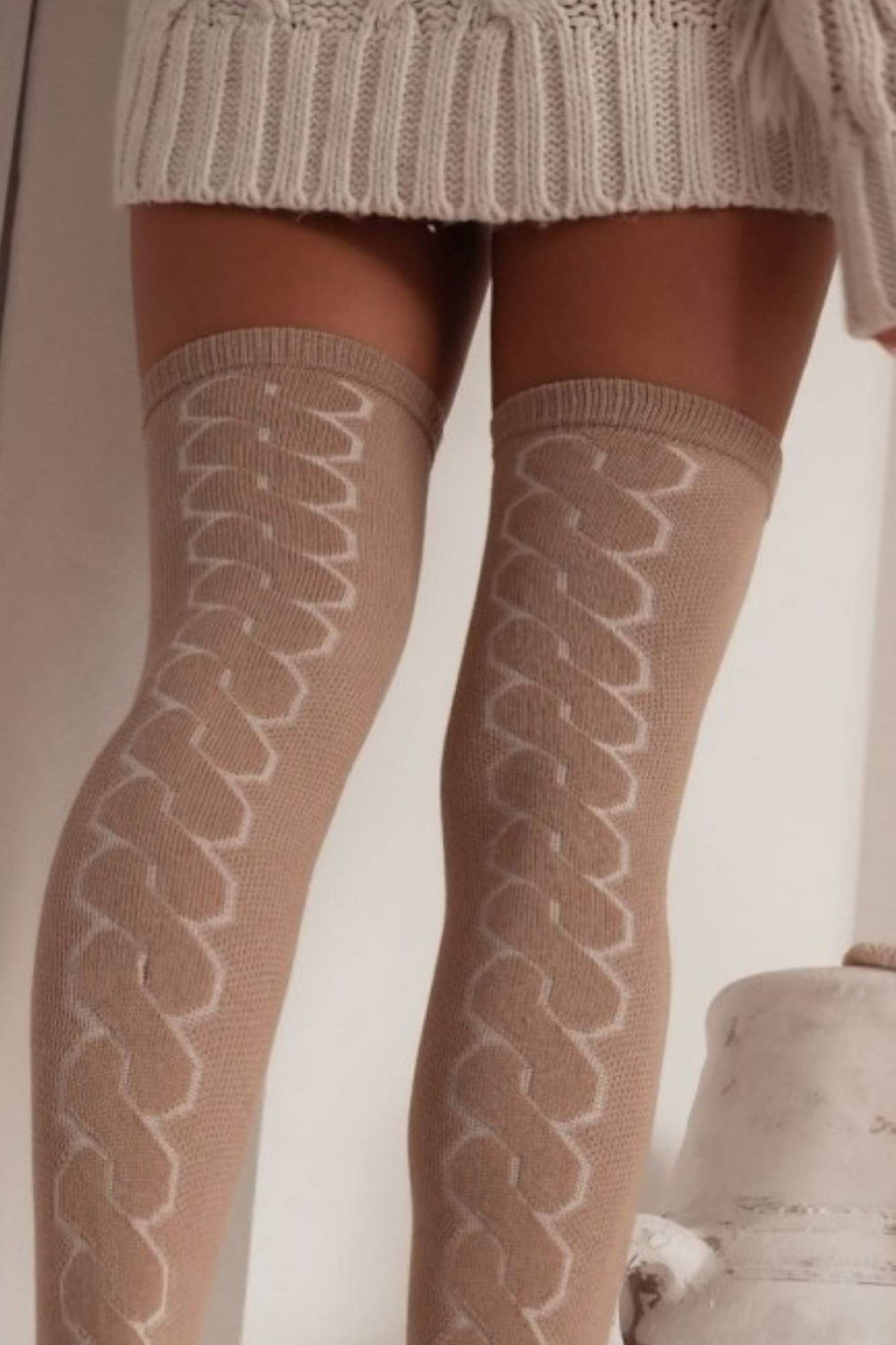 Close-up of beige openwork over-knee socks – delicate back braid pattern on soft breathable fabric
