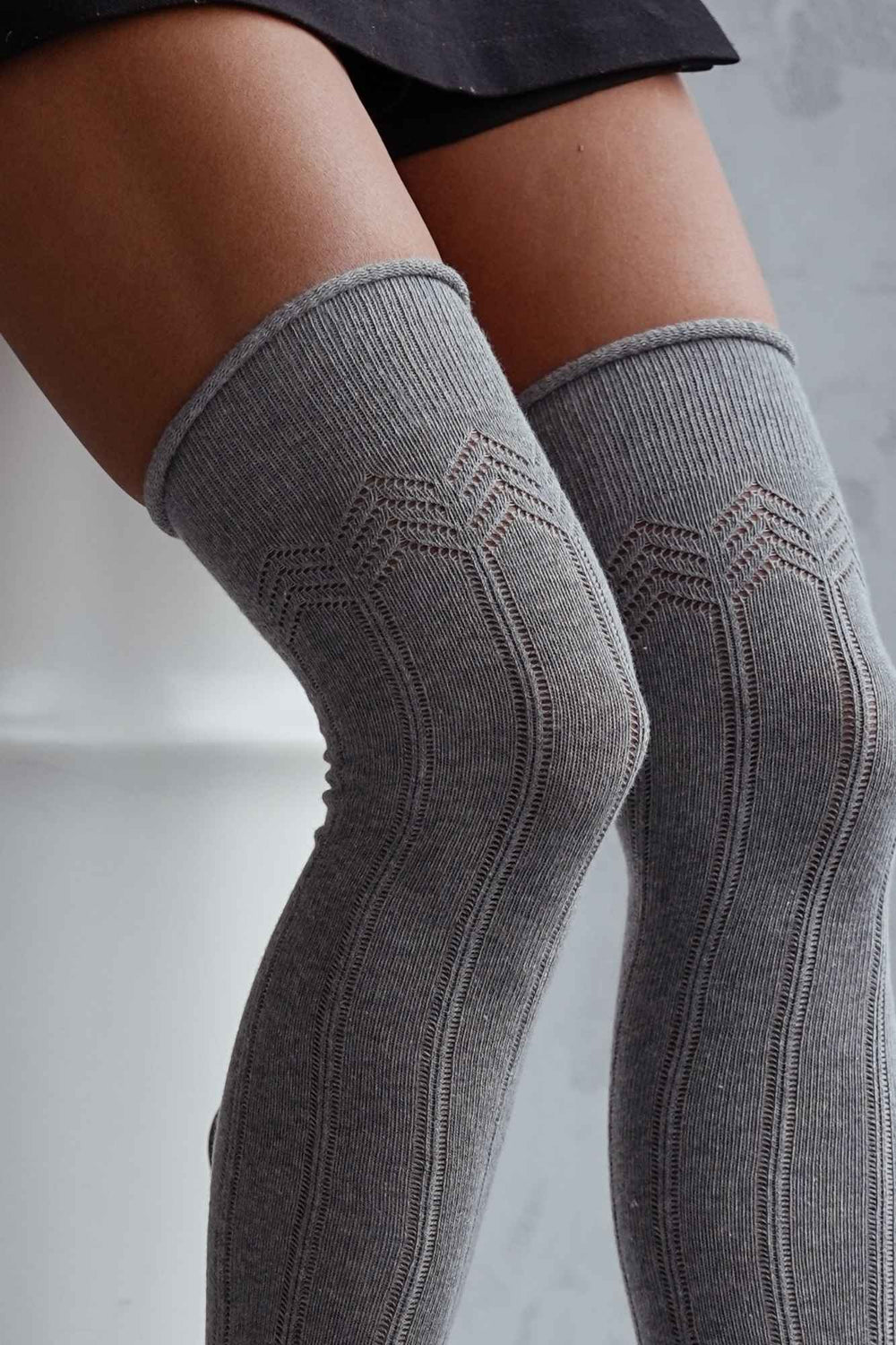 Close-up of melange cotton openwork over-the-knee socks – delicate lace knit pattern on soft fabric
