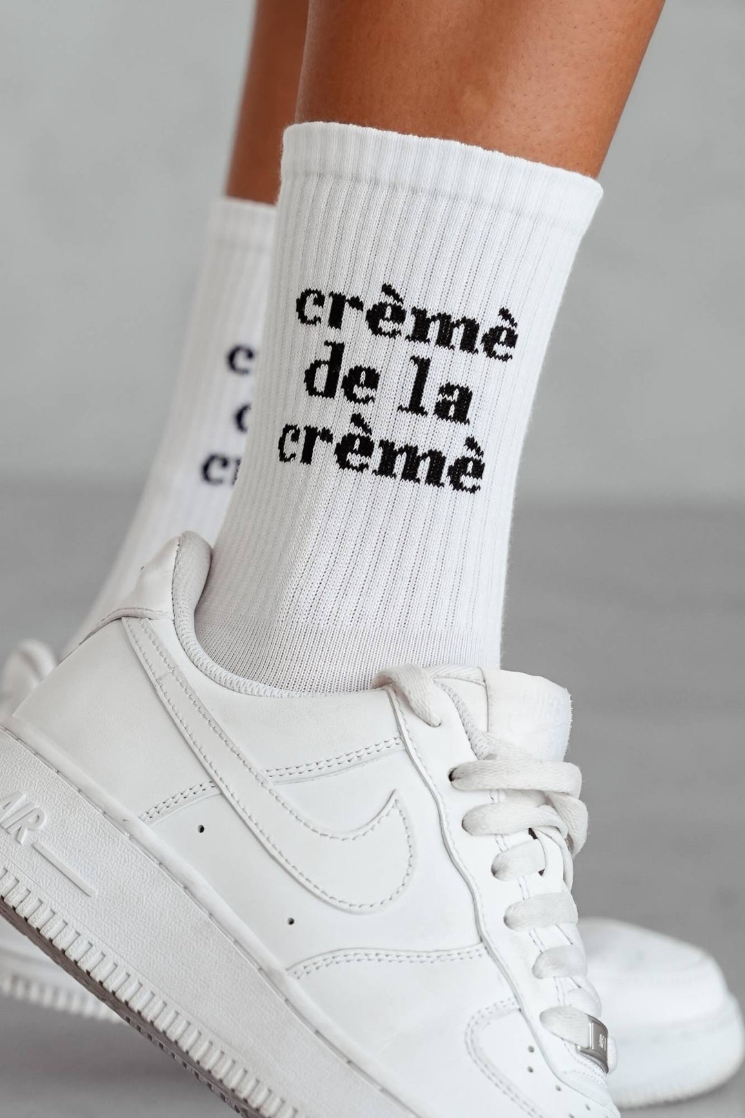Close-up of white cotton socks with Crème de la Crème lettering – breathable fabric detail
