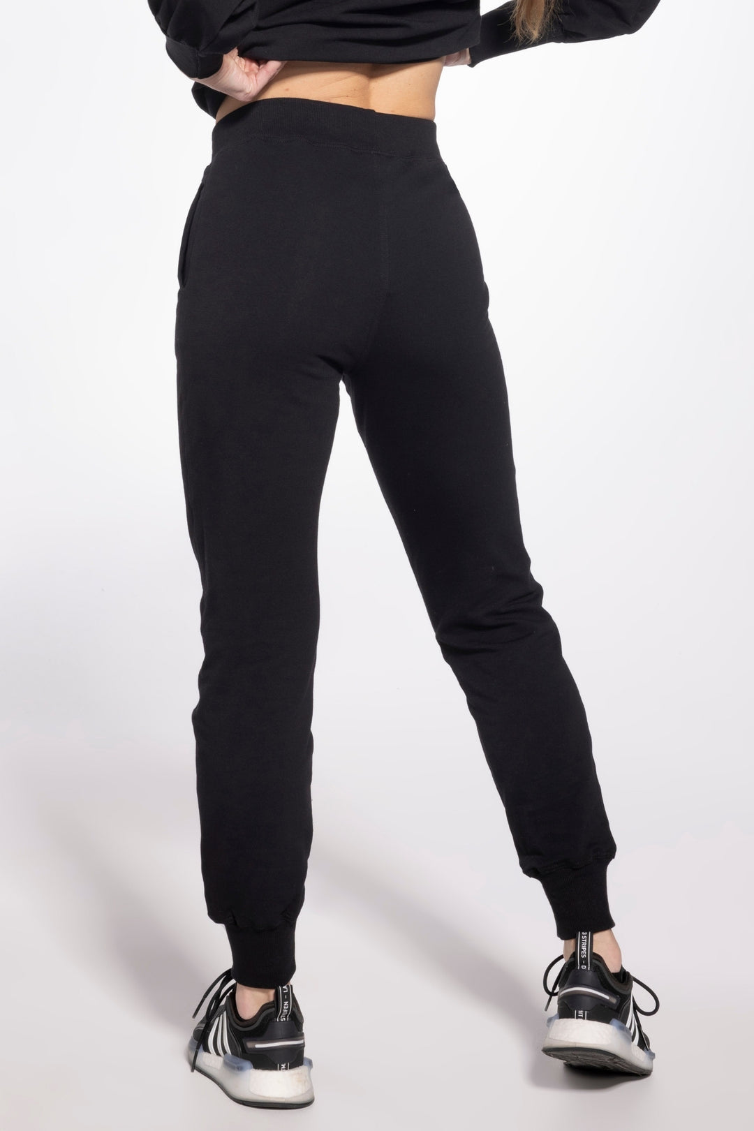 Person wearing black sweatpants on a white background