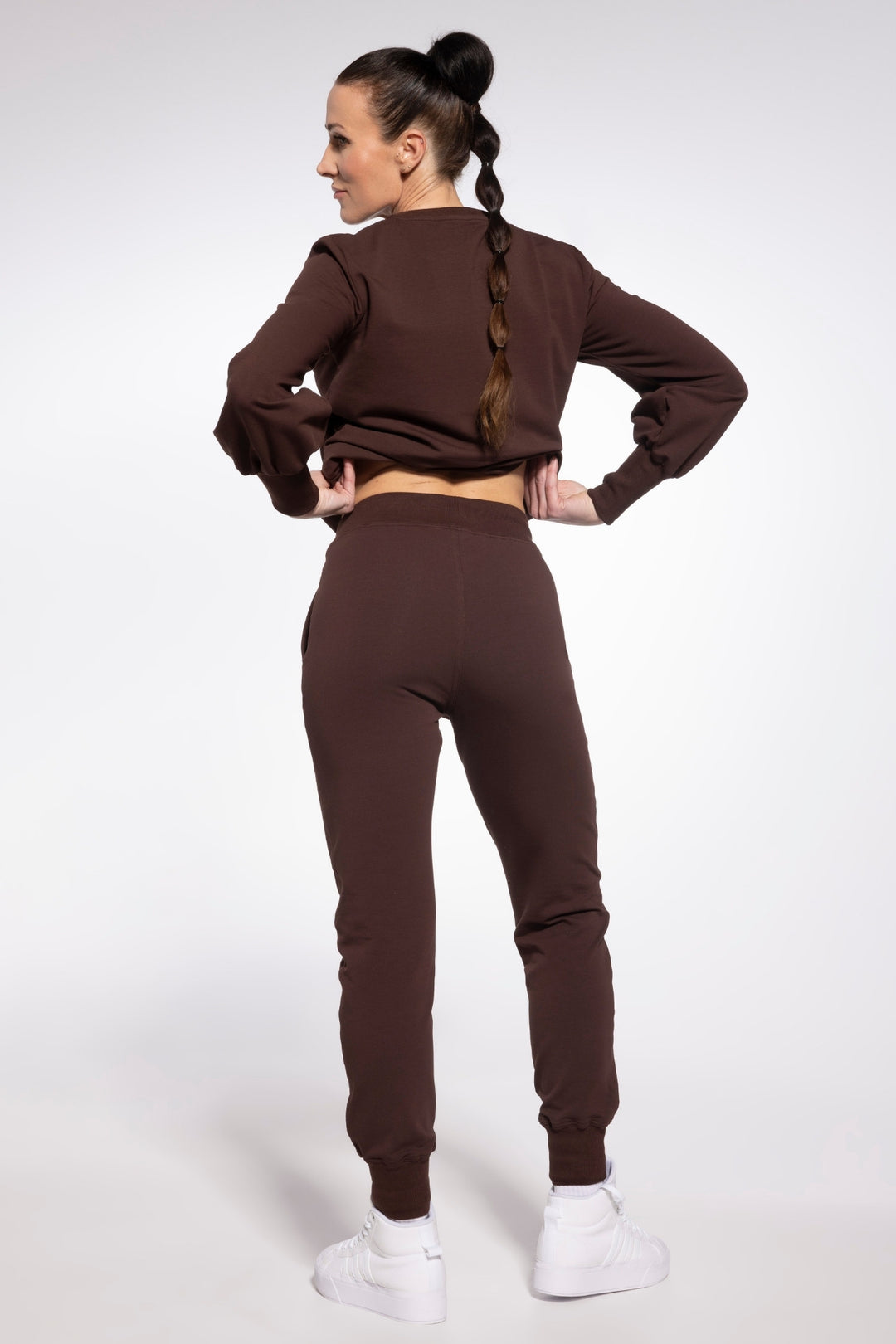 Woman wearing a brown tracksuit on a white background