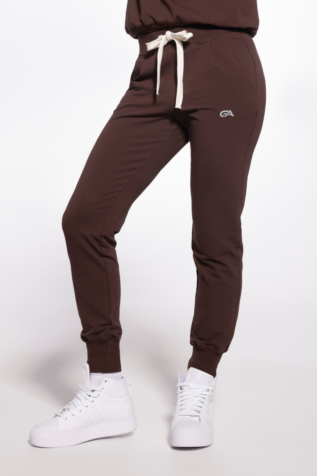 Brown jogger pants with a logo on a white background